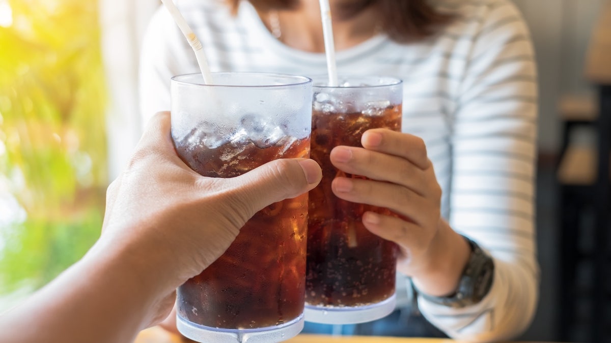 Two people toasting with soda