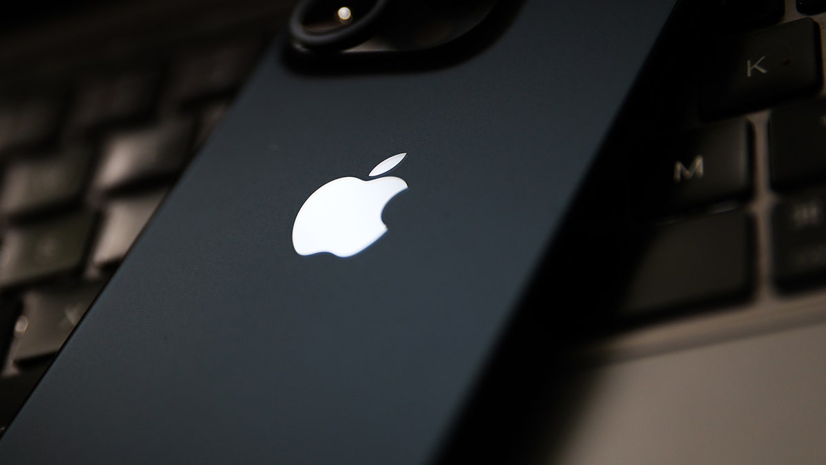 iPhone resting on a laptop.