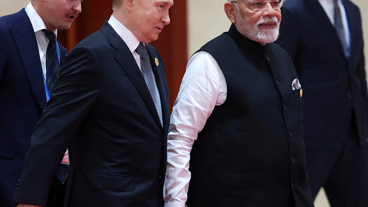Russian President Vladimir Putin and Indian Prime Minister Narendra Modi hold hands