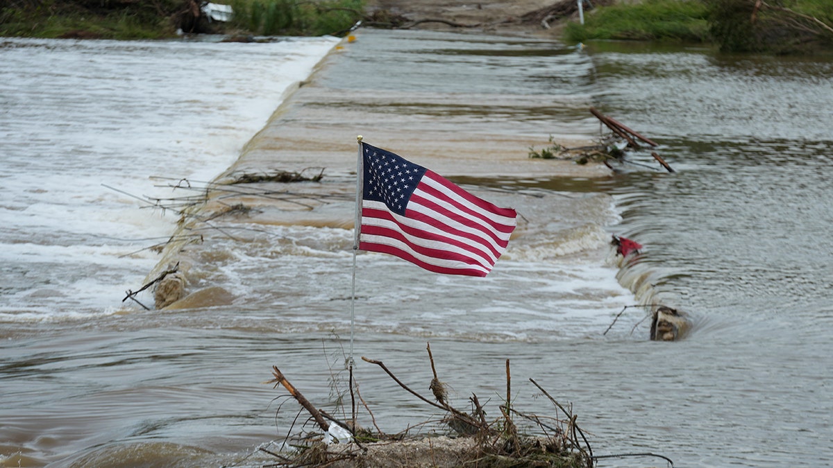 Flooded roadway with U.S. flag at Guadalupe River in Texas