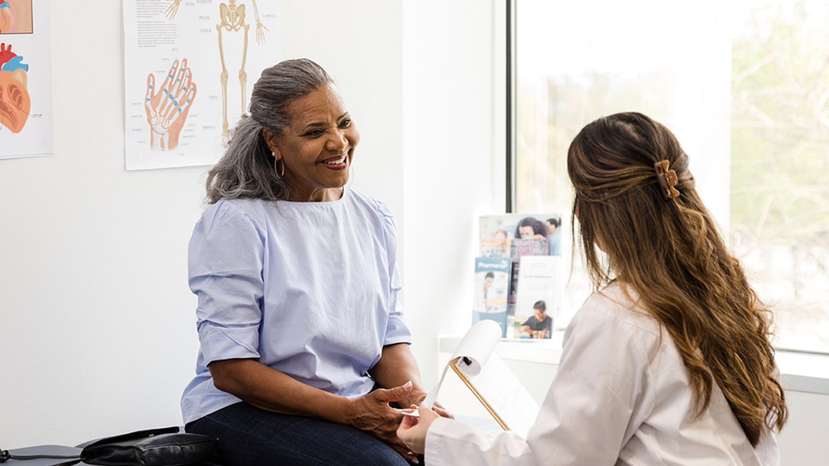 Doctor speaks to happy female patient