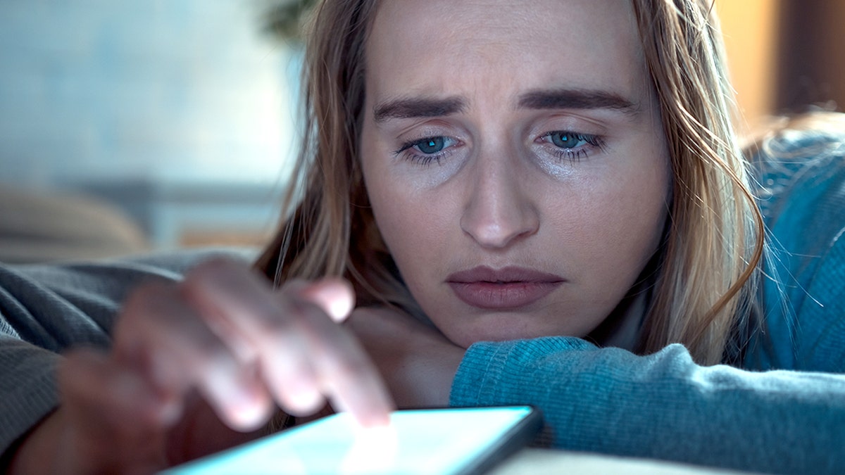 Sad woman scrolling on the phone