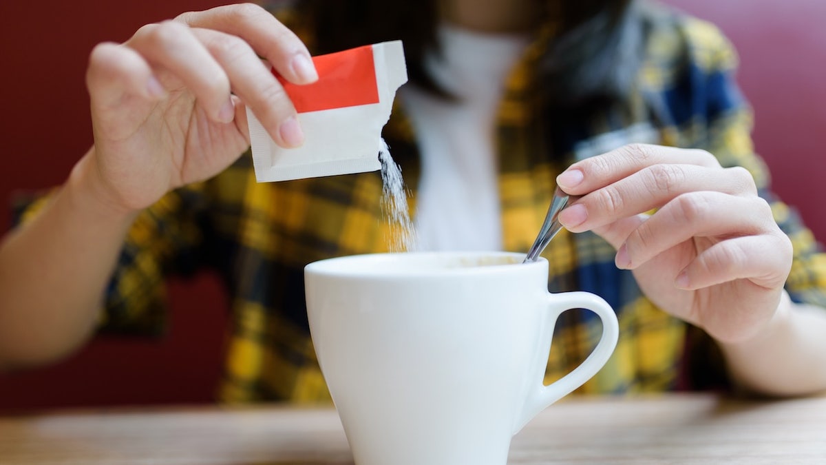 Woman pours sugar into a cup