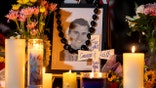 Rosary beads cover a photograph of Charlie Kirk at a makeshift memorial.