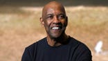 Actor Denzel Washington smiles for the cameras in Paris.