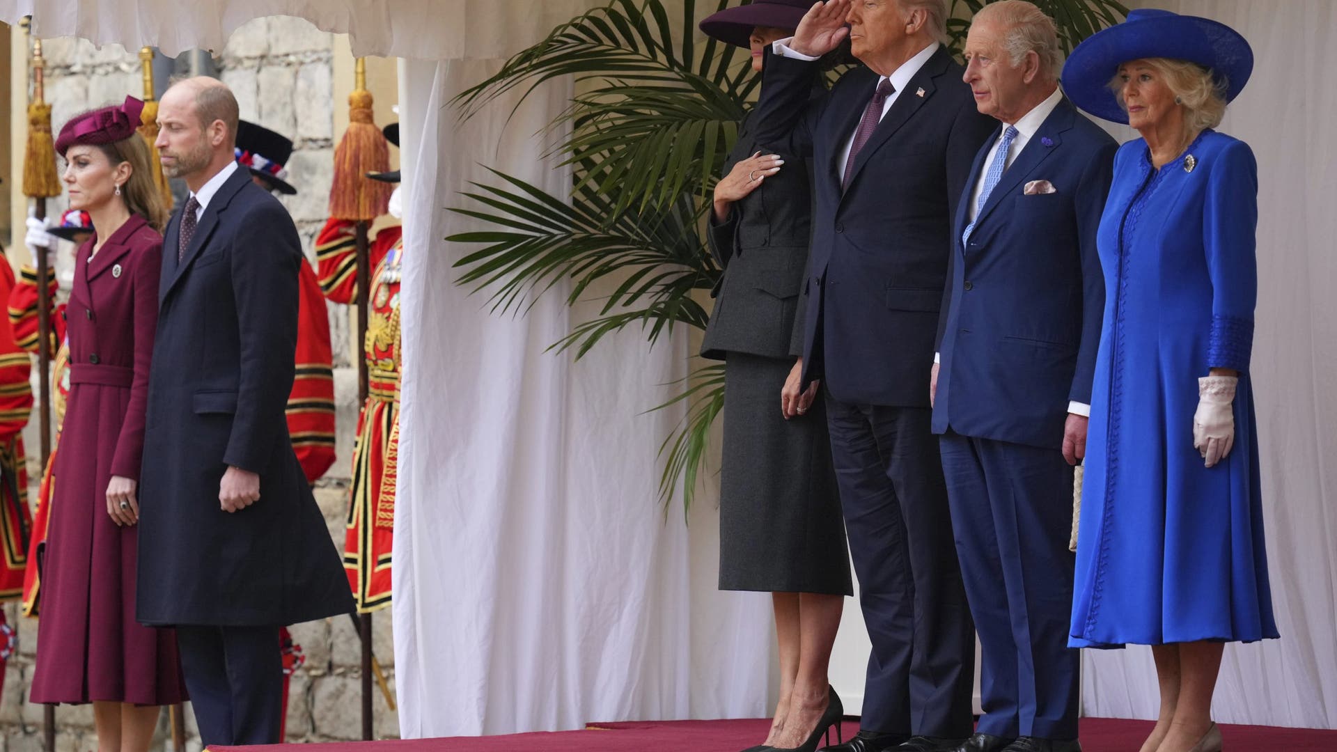 President Donald Trump salutes beside King Charles III and Queen Camilla, with Melania Trump on the left, while Kate and Prince William listen during the national anthem at Windsor Castle on September 17, 2025.