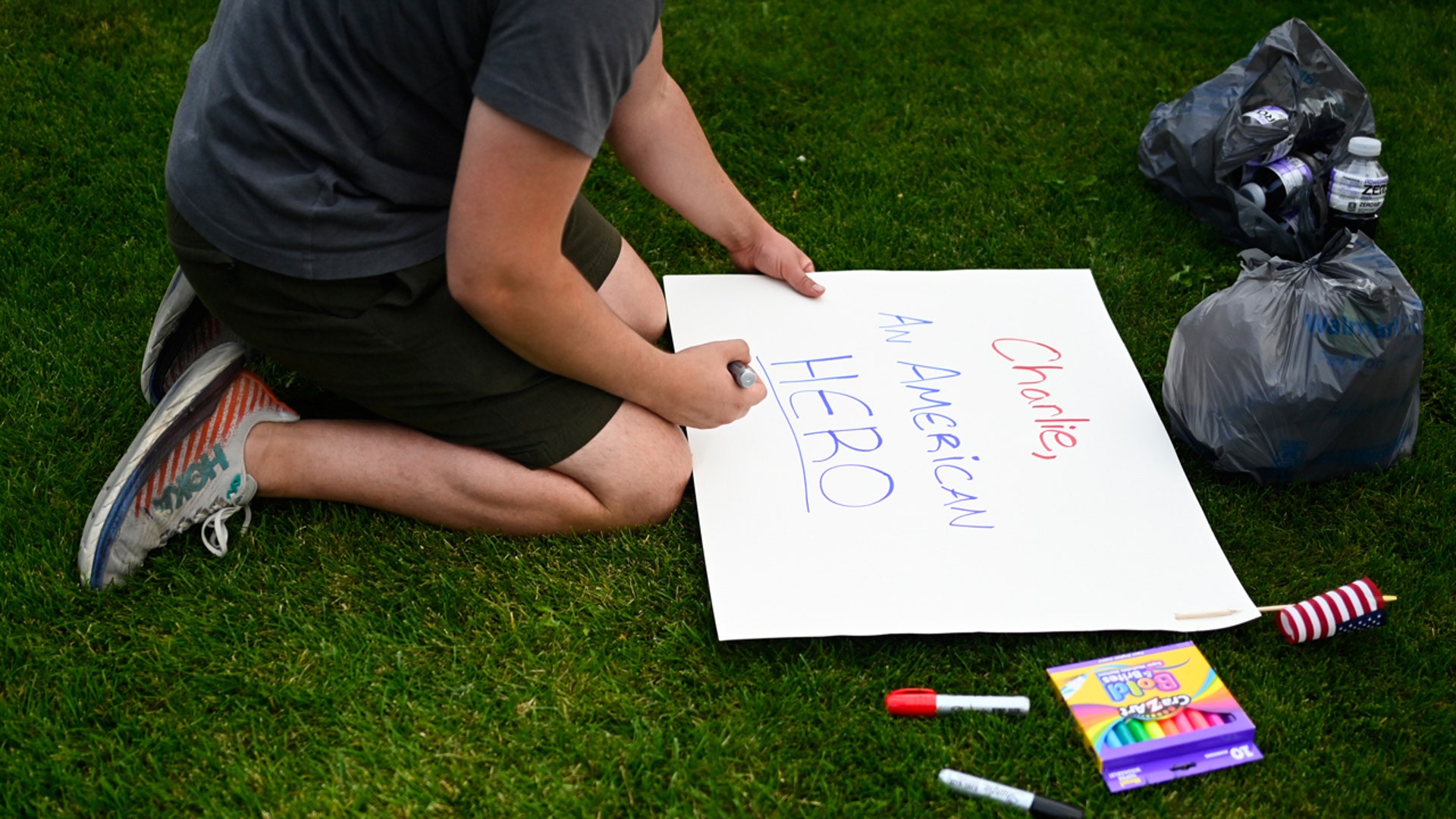 Boy making Charlie Kirk memorial sign