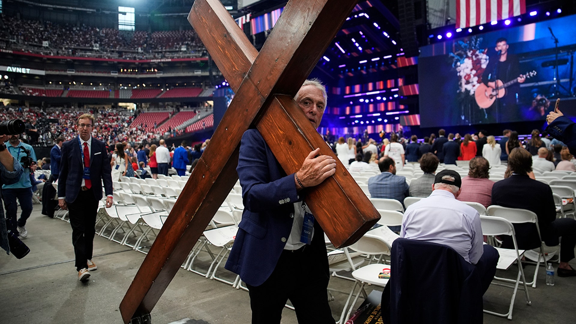 Dan Beazley carries a cross inside the stadium.