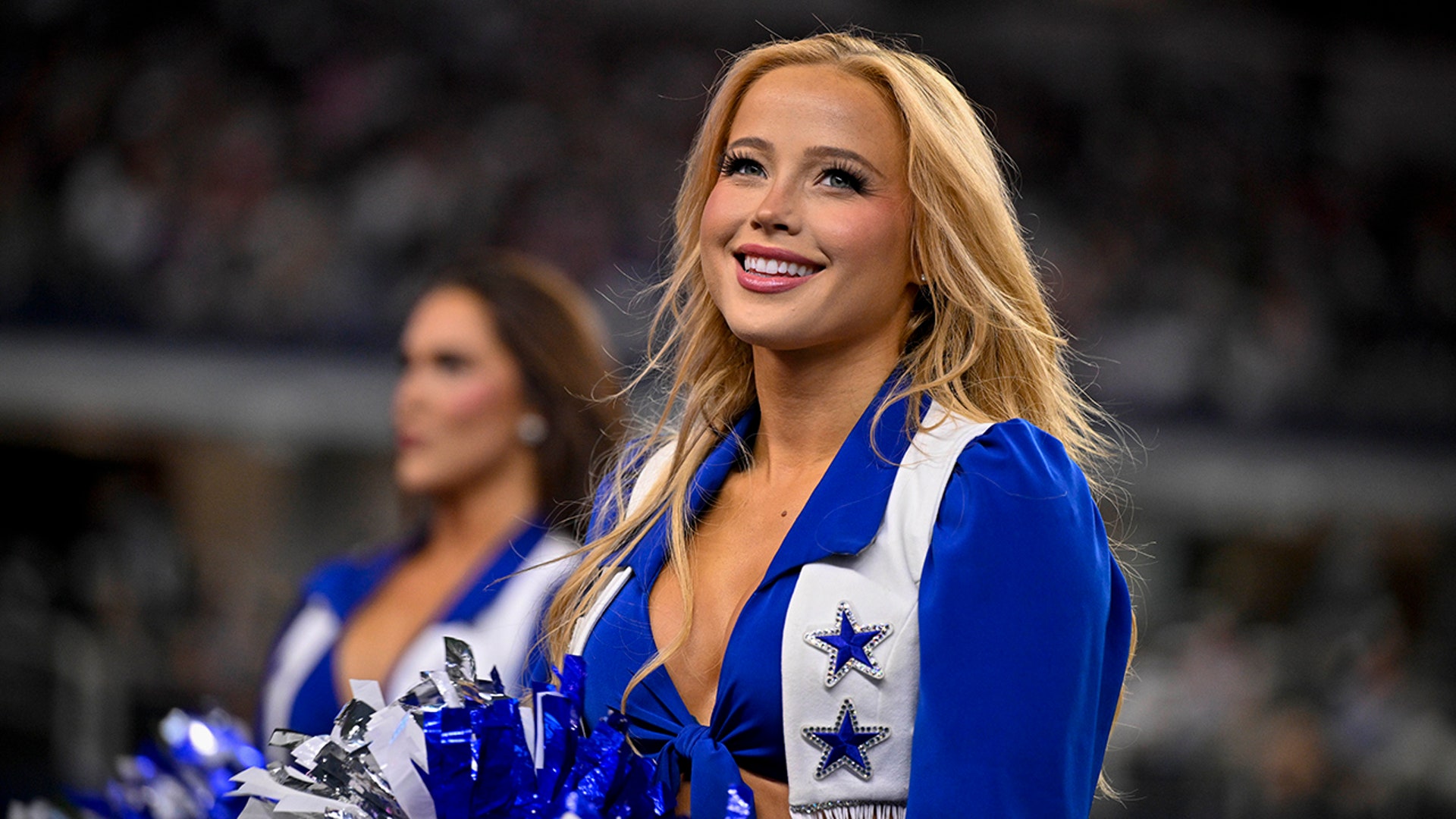 A Cowboys cheerleader looks on
