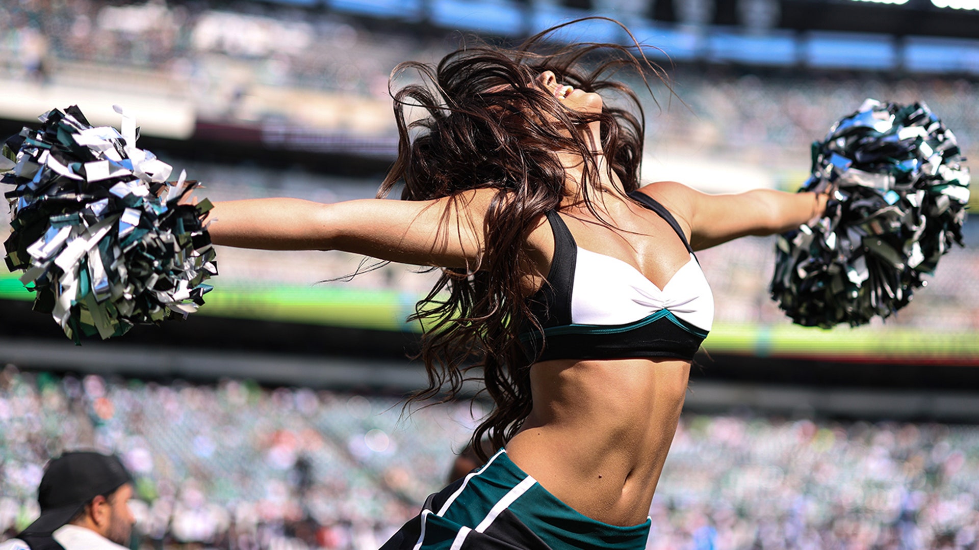 An Eagles cheerleader mid-dance