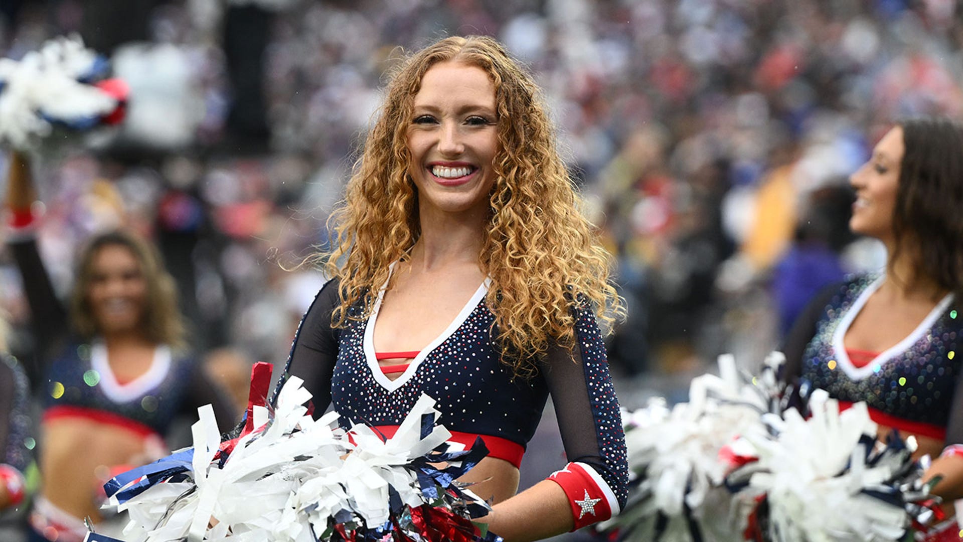 A Patriots cheerleader smiles