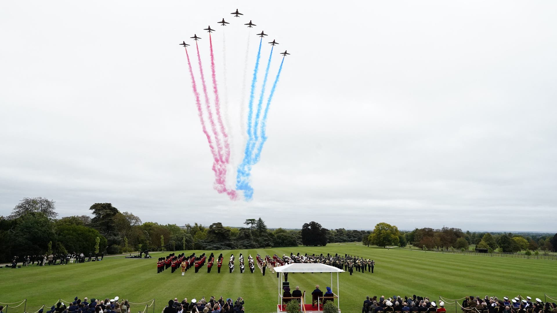 A formation of Royal Air Force jets streaks across the sky with red, white, and blue trails above Windsor Castle’s ceremony.