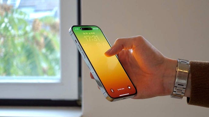 A man holding and using an iPhone