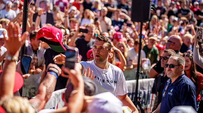 Charlie Kirk surrounded by a large audience, tosses hats to the crowd shortly before his assassination in Utah