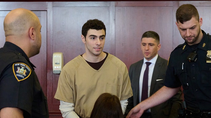 Luigi Mangione seated in court as judge drops terrorism charges.