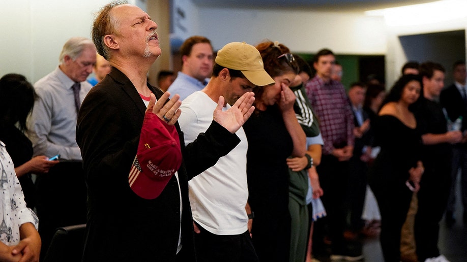 Mourners pray in a lobby after Charlie Kirk vigil