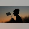 Boy waves flag at Charlie Kirk vigil