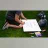 Boy making Charlie Kirk memorial sign