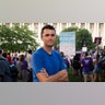 Charlie Kirk in a t-shirt with arms folded