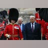 King Charles III and US President Donald Trump, led by a Coldstream Guardsman, inspect the Guard of Honour during a ceremonial welcome at Windsor Castle.