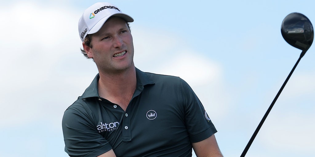 Alligator keeps close eye on PGA Tour golfer Vince Whaley while he takes swing near water