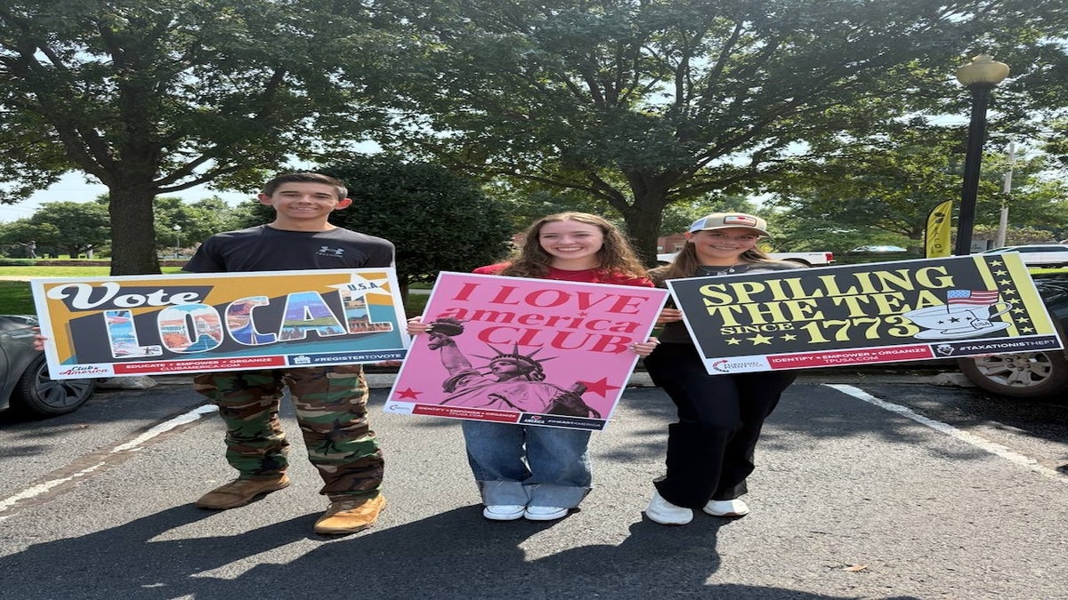 Secondary school students at the American Club carry signs