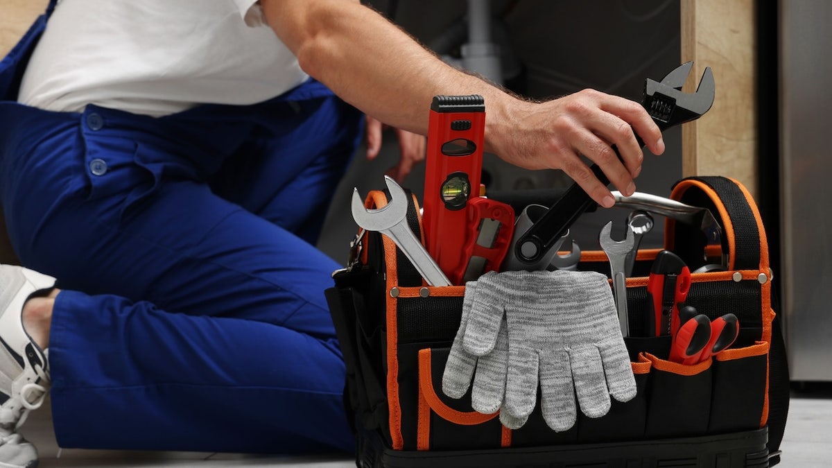taking adjustable wrench from tool bag
