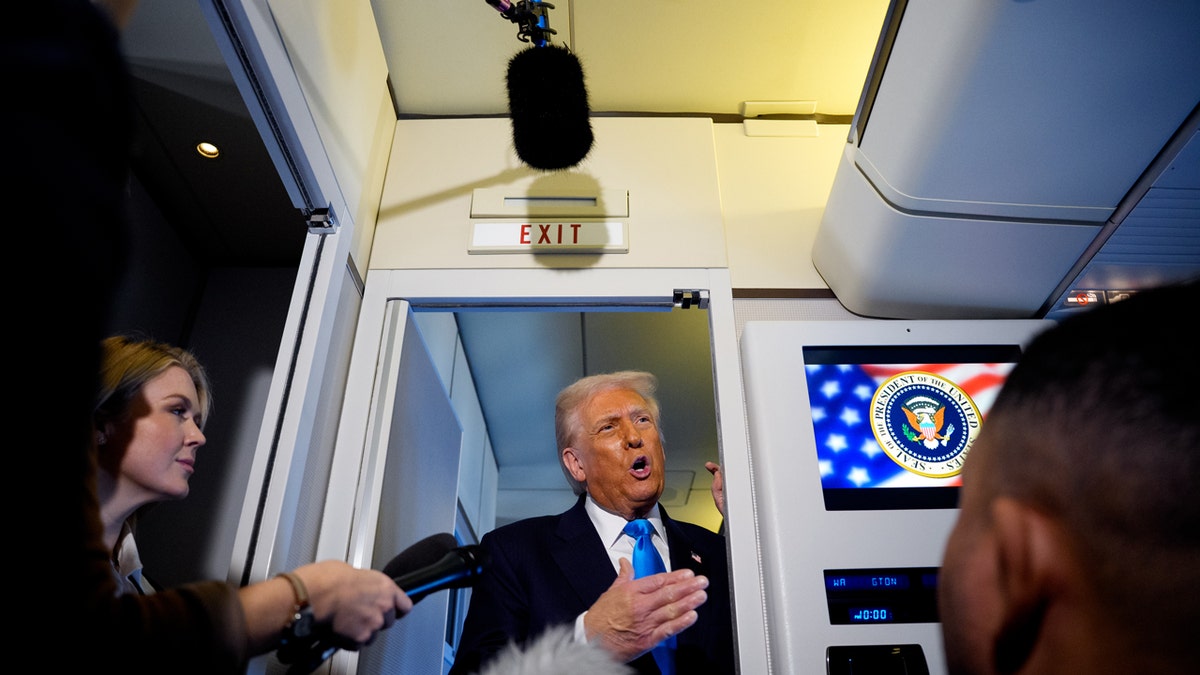 U.S. President Donald Trump speaks to journalists aboard Air Force One