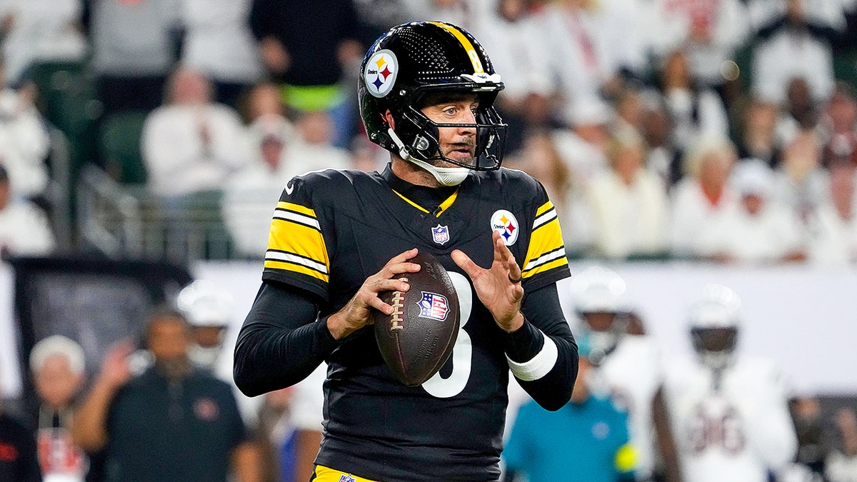 Aaron Rodgers terlihat mengoper
