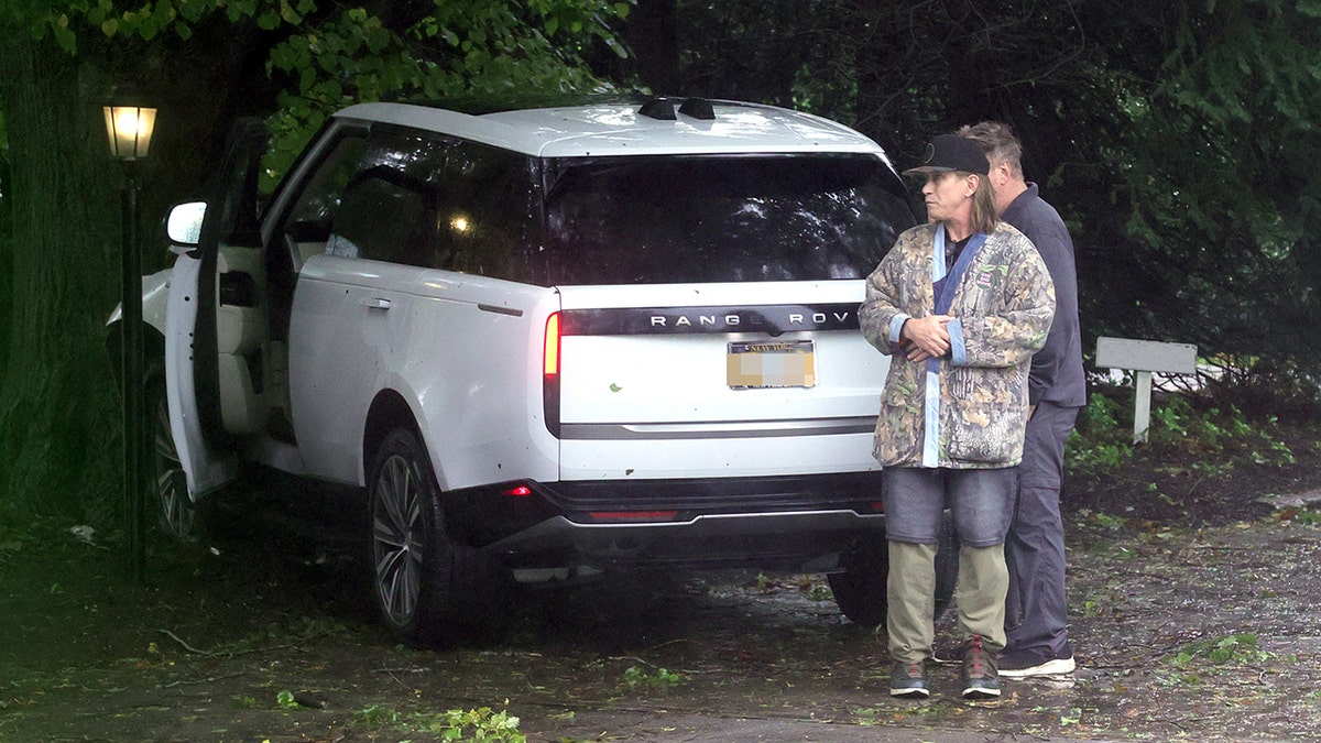 Alec and Stephen Baldwin stand outside car crash