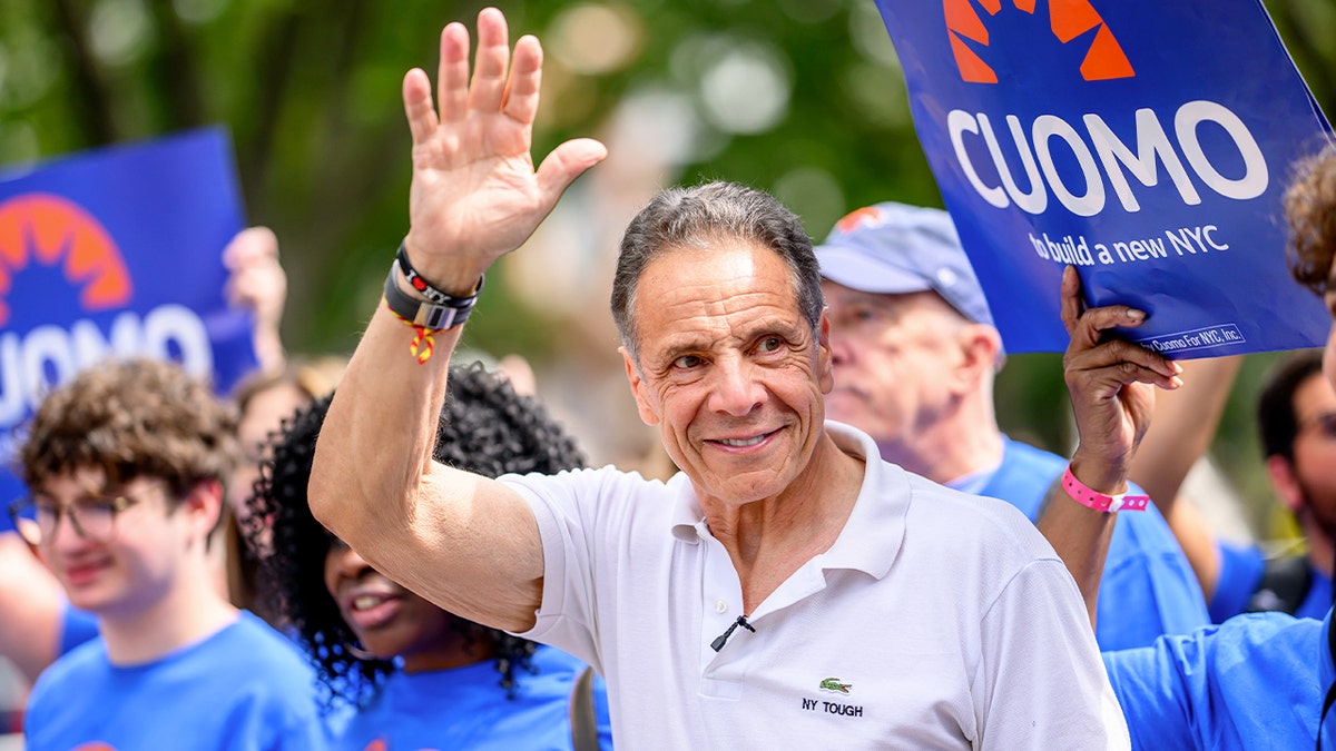 Andrew Cuomo waves as he is surrounded by supporters