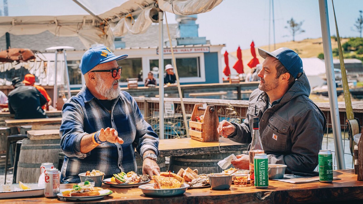 Andrew Zimmern and Barton Seaver enjoy seafood on the water.