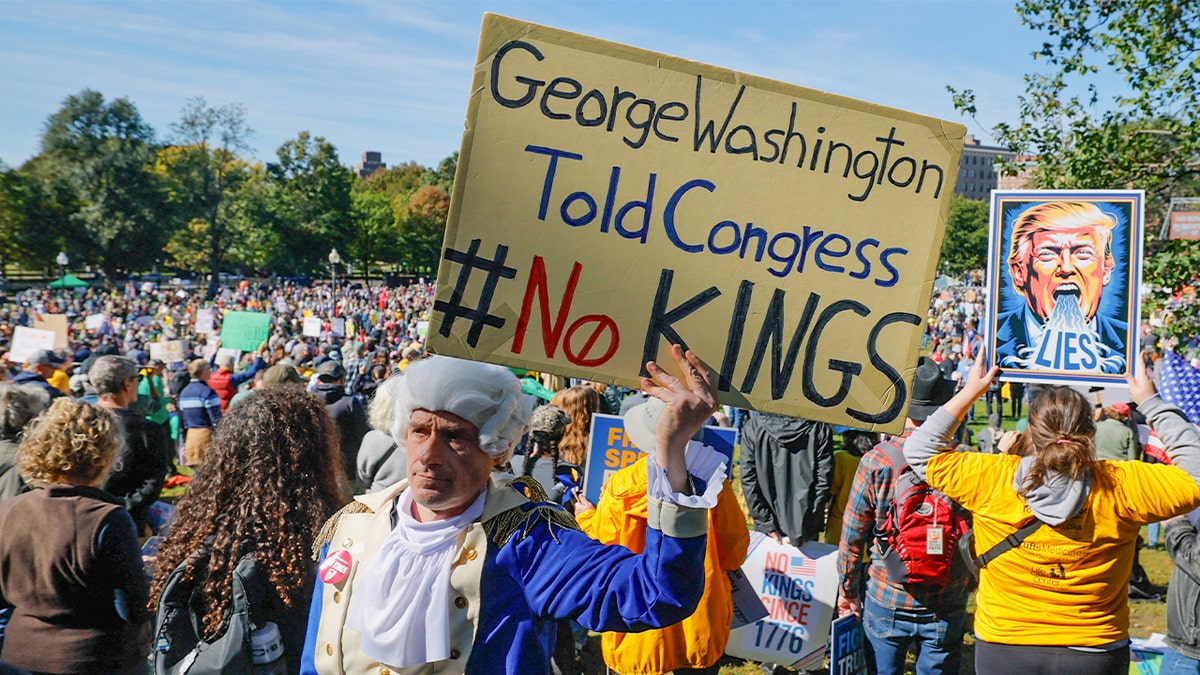 A man dressed as former U.S. President George Washington displays a sign during a "No Kings" protest against U.S. President Donald Trump's policies in Boston, Mass., Oct.18, 2025.