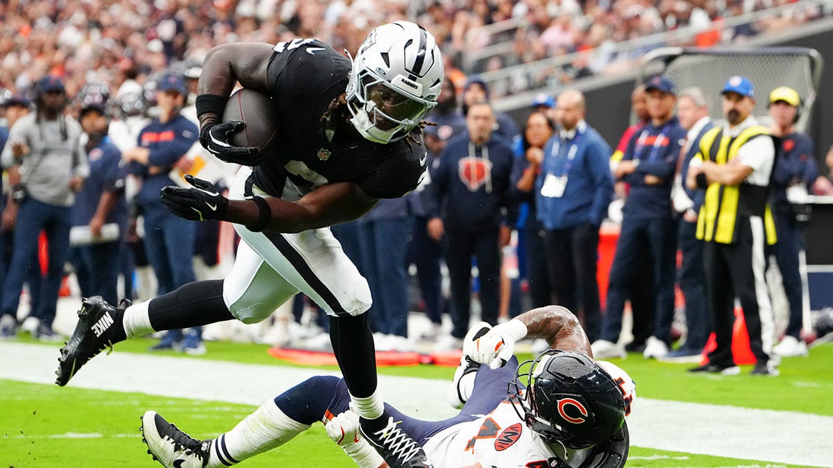 Ashton Jeanty joga jogador do Bears no chão