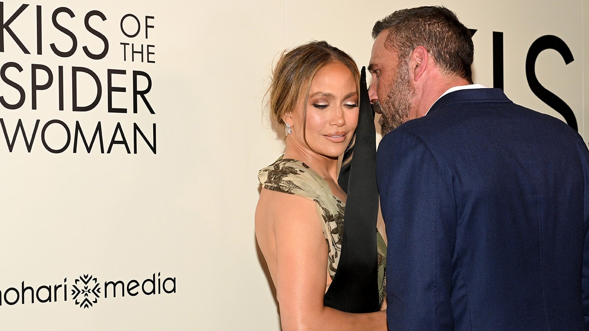 Ben Affleck whispering something into Jennifer Lopez's ear on the red carpet at the premiere of "Kiss of the Spider Woman" in October 2025.