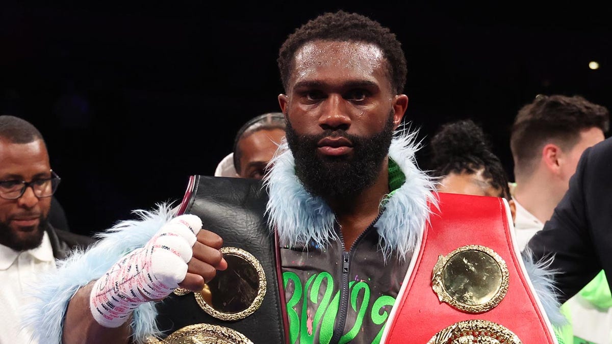 Jaron Ennis with boxing belts around shoulders