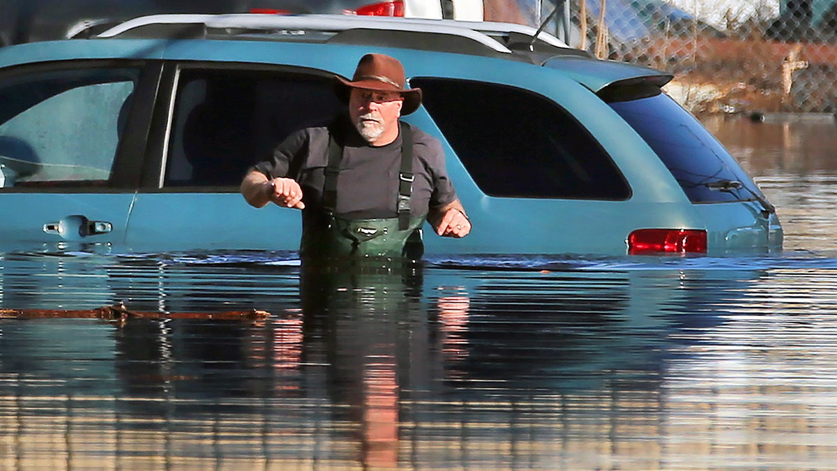 Un hombre atraviesa las aguas de la cintura