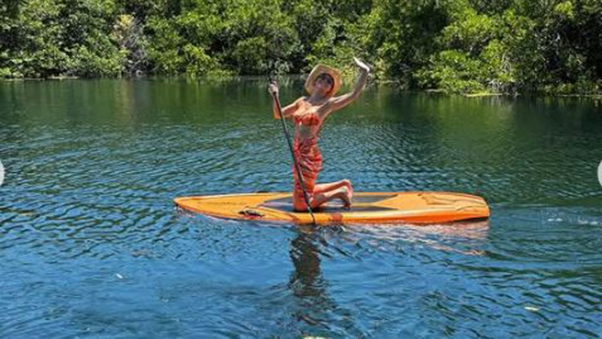 Brie Larson paddleboarding and waving