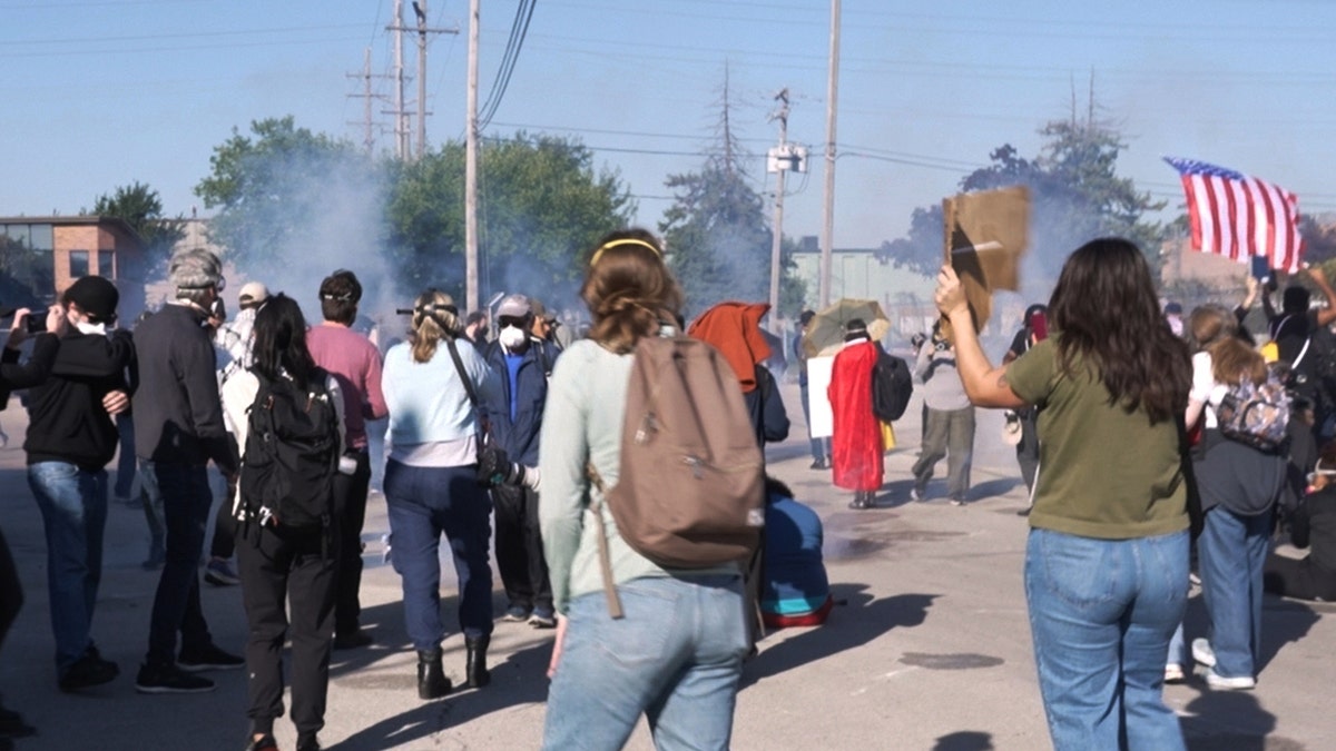 Manifestantes de hielo caminando cerca de gas lacrimógeno