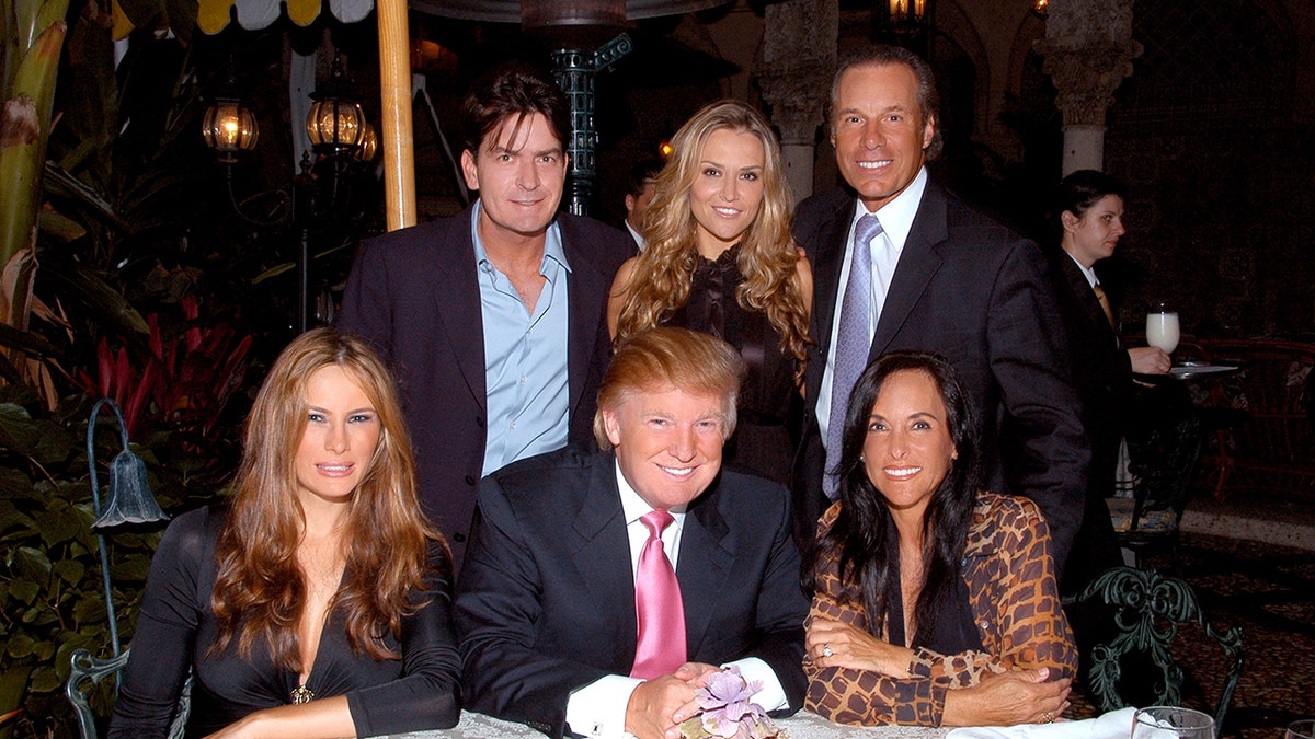 Charlie Sheen and Brooke Mueller posing with her parents, Donald Trump and Melania Trump at dinner.