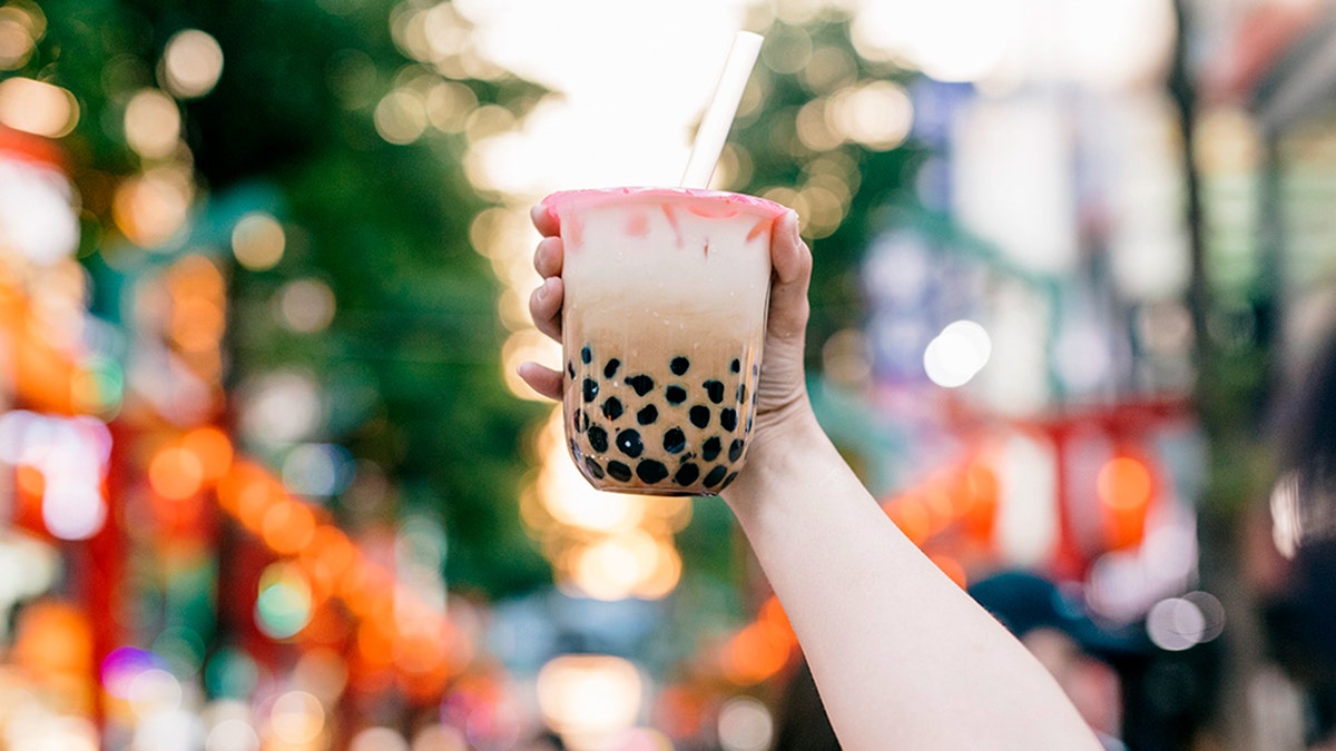 hand holds bubble tea with black pearls