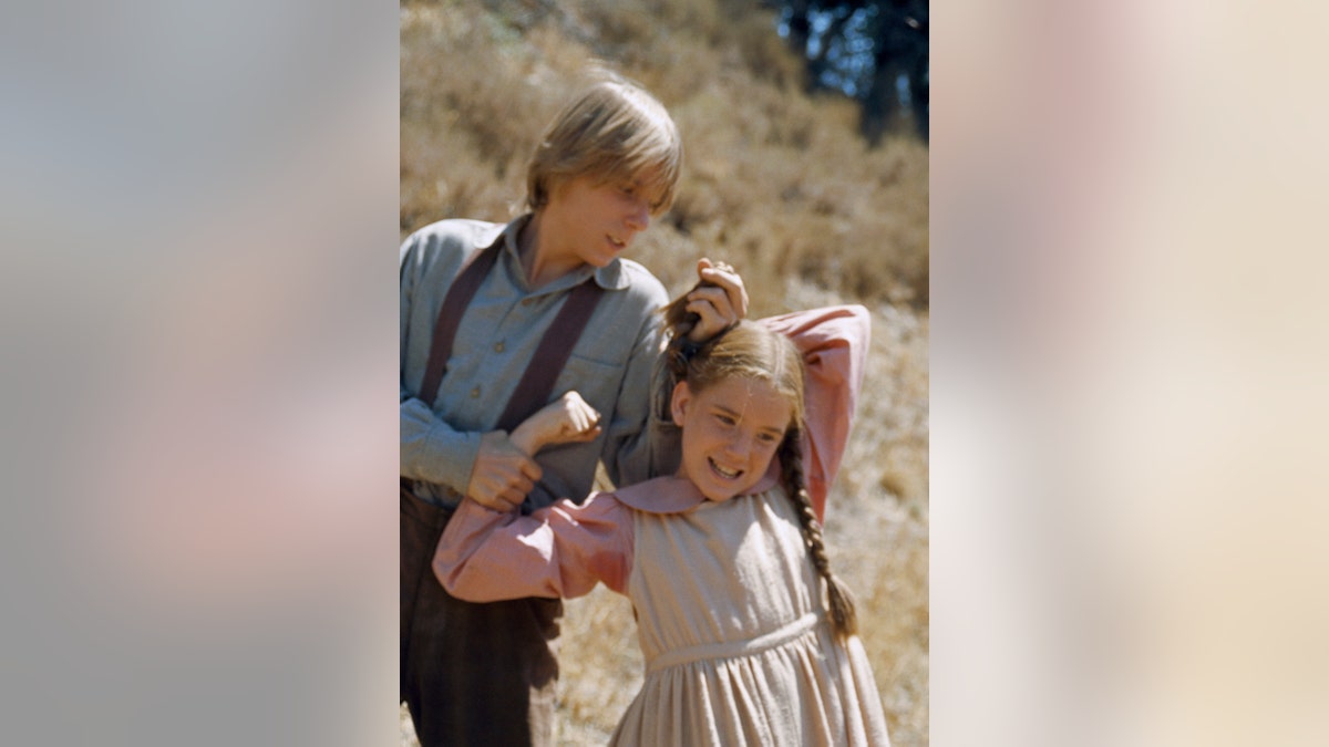 Michael LeClair pulling Melissa Gilbert's hair. She is in character as Laura Ingalls.
