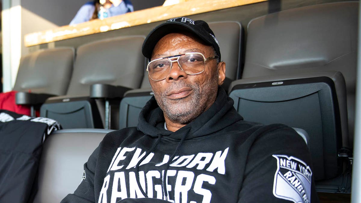 Carl Banks looks on from seats