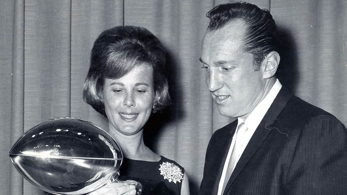 Carol and Al Davis hold Super Bowl trophy
