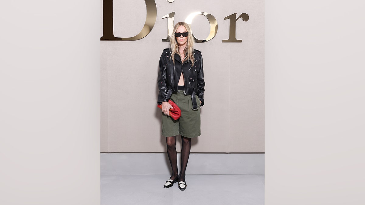 Charlize Theron in a leather jacket with nothing underneath and green shorts at Paris Fashion Week in October 2025.