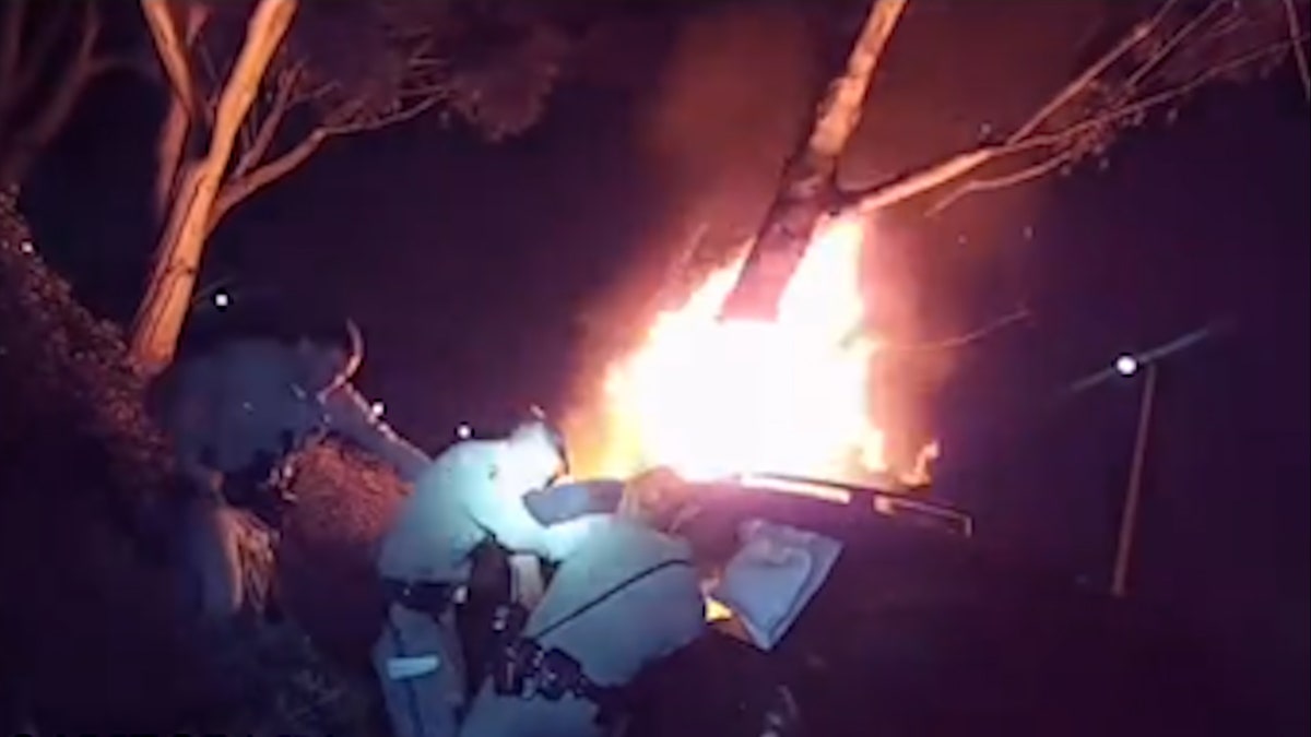 officers reach into burning vehicle to pull out driver from burning car