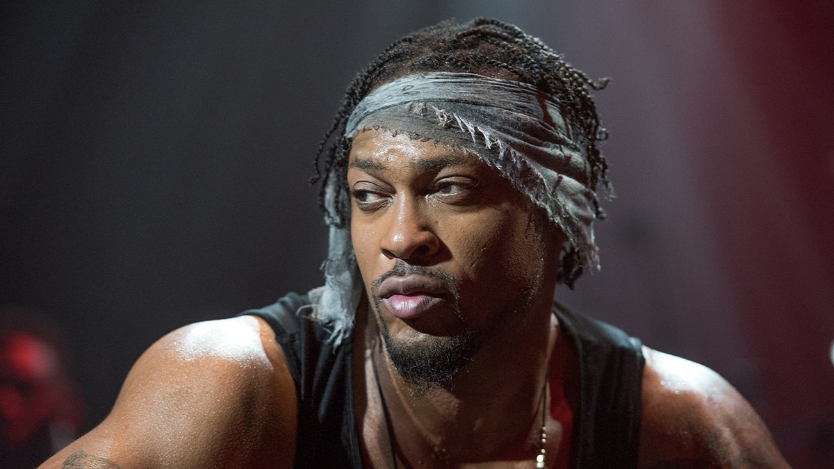 D'Angelo wears a black tank top with bandana around his head