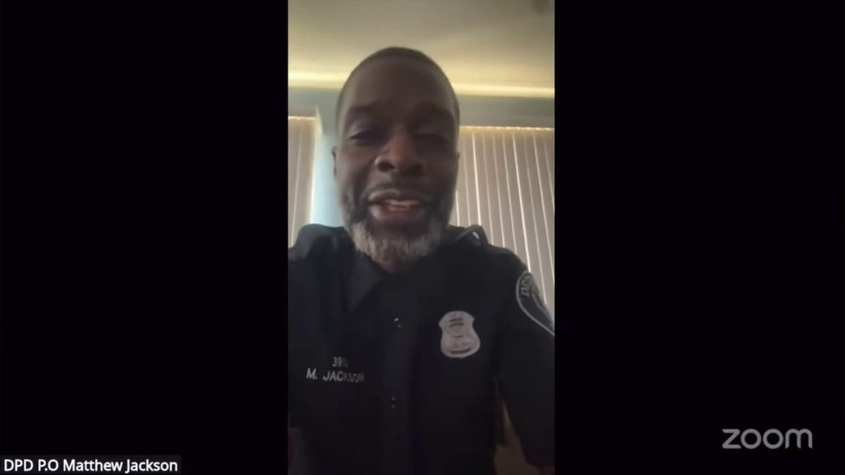 officer speaks to phone during virtual court hearing on zoom