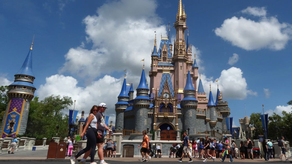 People walking past Cinderella's Castle at Magic Kingdom Park in Orlando, Florida