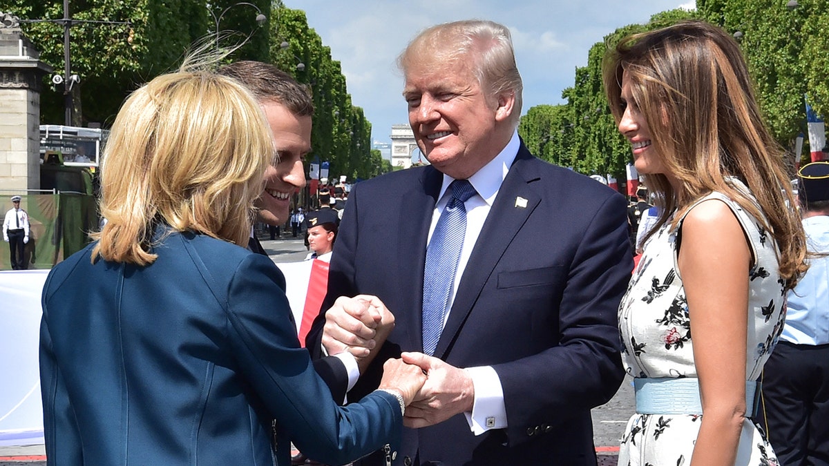 El presidente estadounidense Donald Trump, flanqueado por la primera dama Melania Trump, estrecha la mano del presidente francés Emmanuel Macron y la mano de la esposa de Macron, Brigitte Macron.